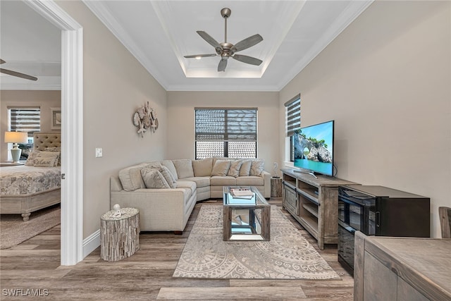 living room with crown molding, light wood-type flooring, and ceiling fan