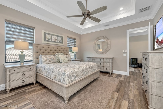 bedroom with multiple windows, wood-type flooring, crown molding, and ceiling fan