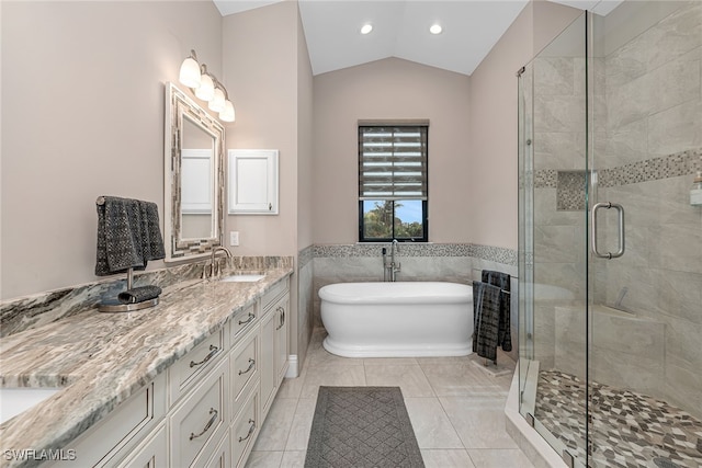 bathroom featuring lofted ceiling, tile patterned floors, independent shower and bath, tile walls, and vanity