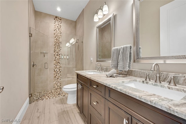 bathroom featuring a shower with door, toilet, wood-type flooring, and vanity