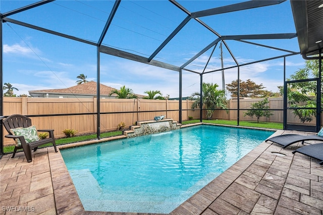 view of pool with a patio, pool water feature, and glass enclosure