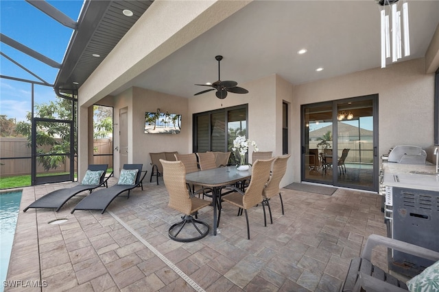 view of patio featuring ceiling fan and glass enclosure