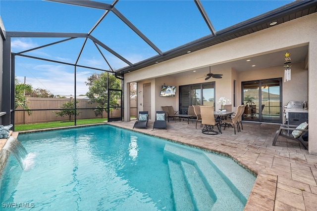 view of swimming pool featuring a patio, pool water feature, a lanai, and ceiling fan