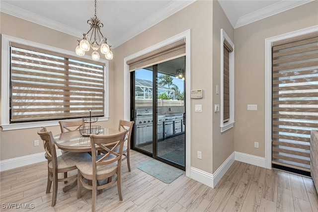 dining area featuring crown molding, light hardwood / wood-style flooring, and an inviting chandelier