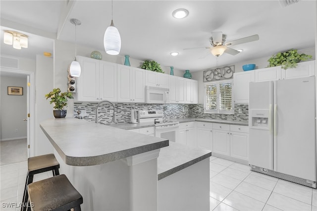 kitchen with white cabinets, kitchen peninsula, decorative light fixtures, and white appliances