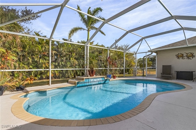 view of swimming pool featuring glass enclosure and a patio