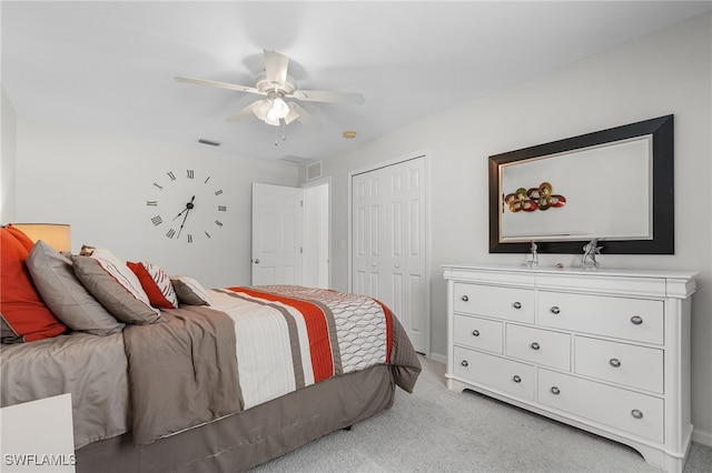 bedroom with ceiling fan, light carpet, and a closet