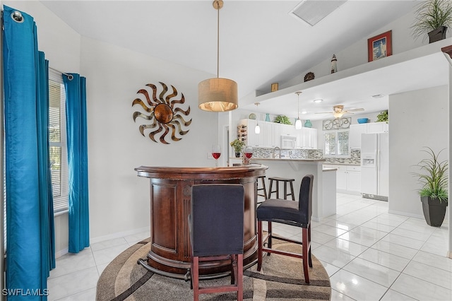 bar with white cabinetry, hanging light fixtures, a healthy amount of sunlight, and white appliances