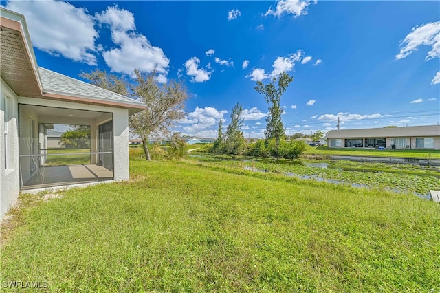 view of yard with a water view and a sunroom