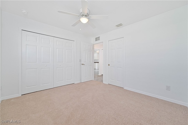 unfurnished bedroom featuring a closet, ceiling fan, and light carpet