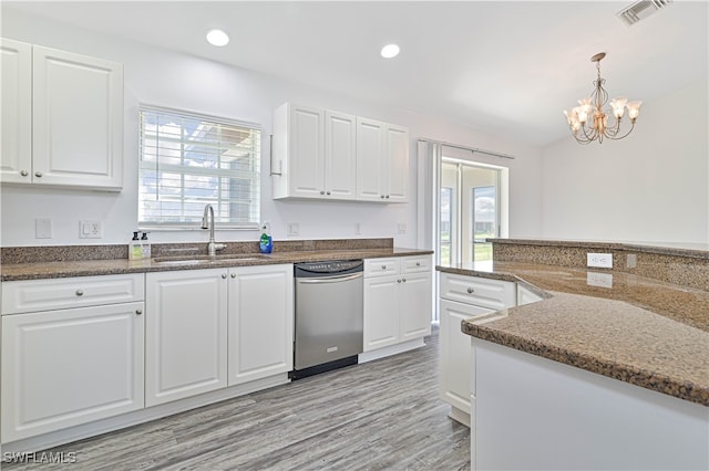 kitchen featuring sink, light wood-type flooring, white cabinetry, pendant lighting, and dark stone countertops