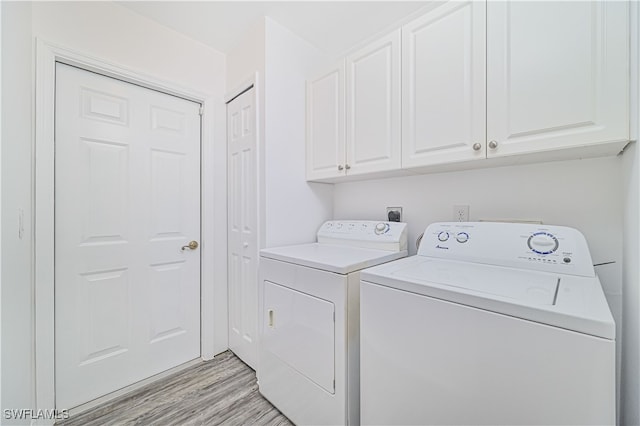 clothes washing area featuring light hardwood / wood-style flooring, cabinets, and separate washer and dryer