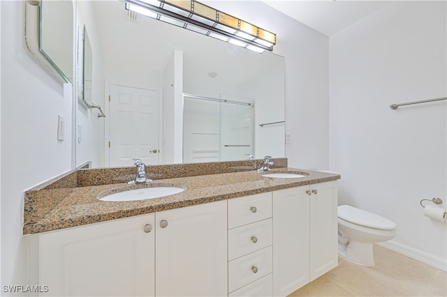 bathroom with a shower with door, vanity, toilet, and tile patterned floors