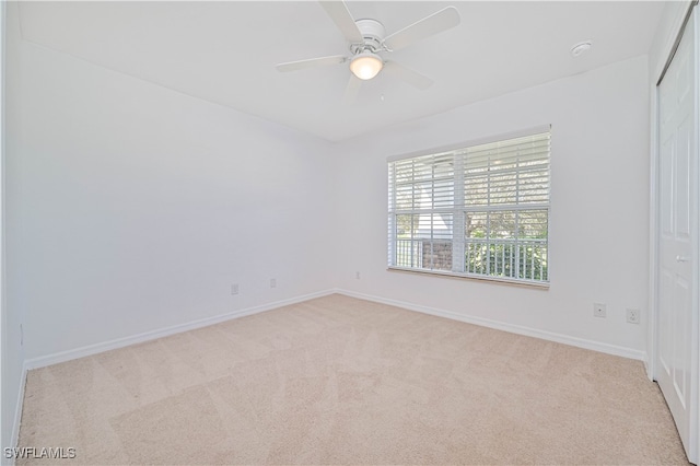 spare room with light carpet and ceiling fan