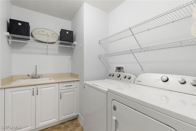 laundry area with separate washer and dryer, sink, and cabinets