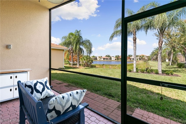 sunroom featuring a water view