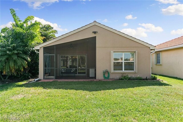 rear view of house with a lawn and a sunroom