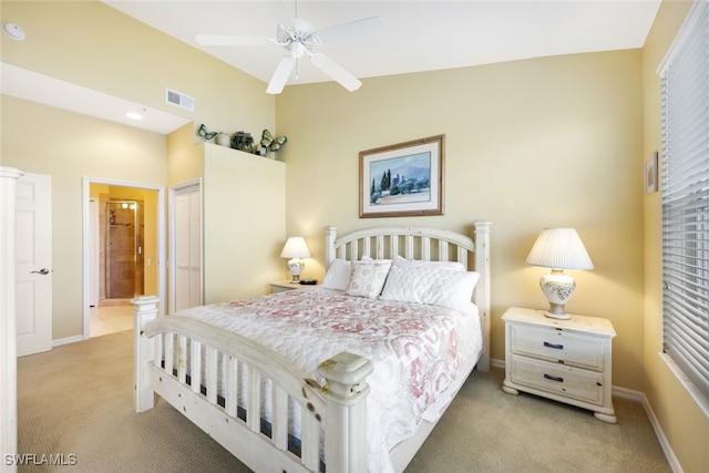 carpeted bedroom with a closet, connected bathroom, and ceiling fan