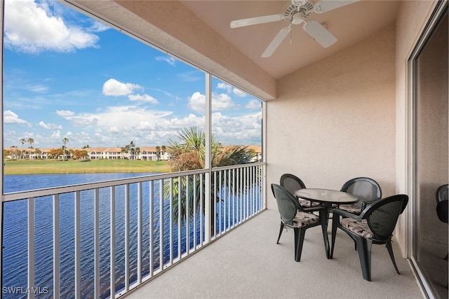 balcony featuring a water view and ceiling fan