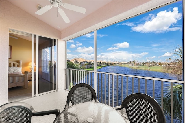 balcony with a water view and ceiling fan