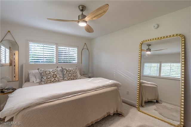 bedroom with ceiling fan, light carpet, and multiple windows