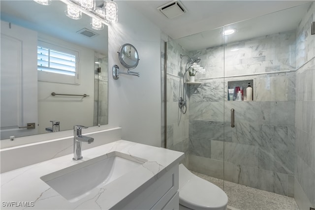 bathroom featuring vanity, toilet, and a shower with shower door