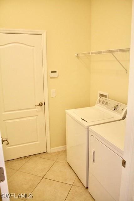 14549 Lanier Ct, Naples, FL 34114 - washroom featuring washing machine and clothes dryer and light tile patterned flooring