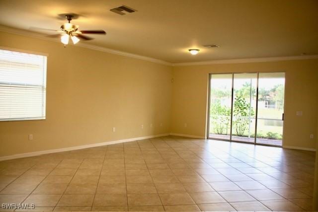 tiled spare room featuring ceiling fan and ornamental molding