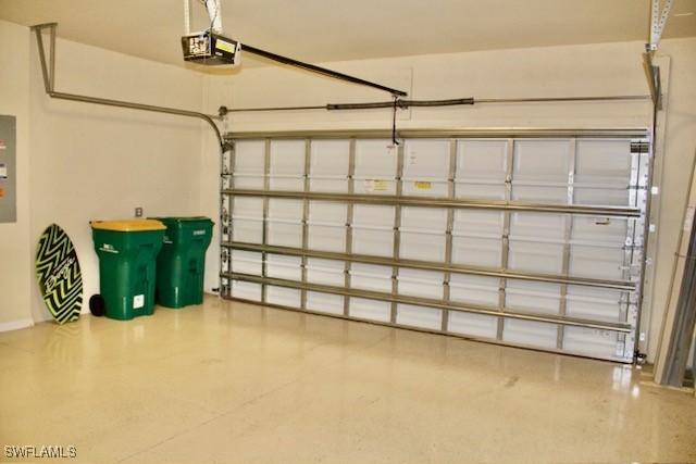 garage with electric panel and a garage door opener