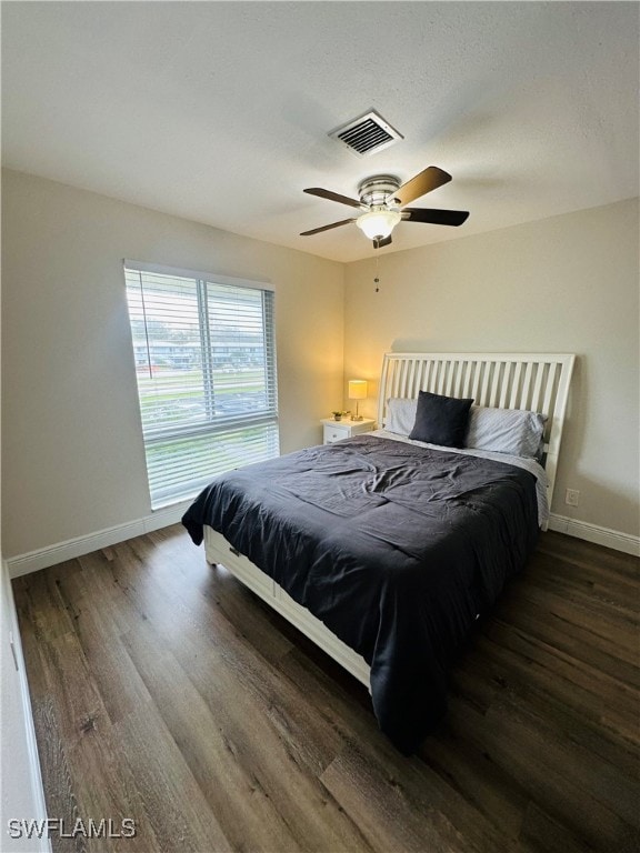 bedroom with dark hardwood / wood-style floors and ceiling fan