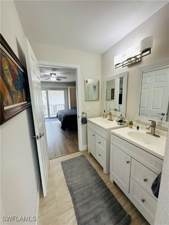 bathroom featuring hardwood / wood-style flooring, ceiling fan, vanity, and a textured ceiling