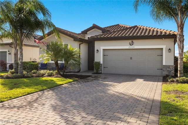 mediterranean / spanish house featuring a front lawn and a garage