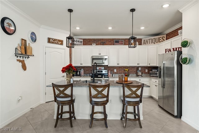 kitchen with pendant lighting, stainless steel appliances, a kitchen island with sink, and dark stone counters