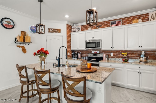 kitchen with pendant lighting, sink, stainless steel appliances, and a center island with sink