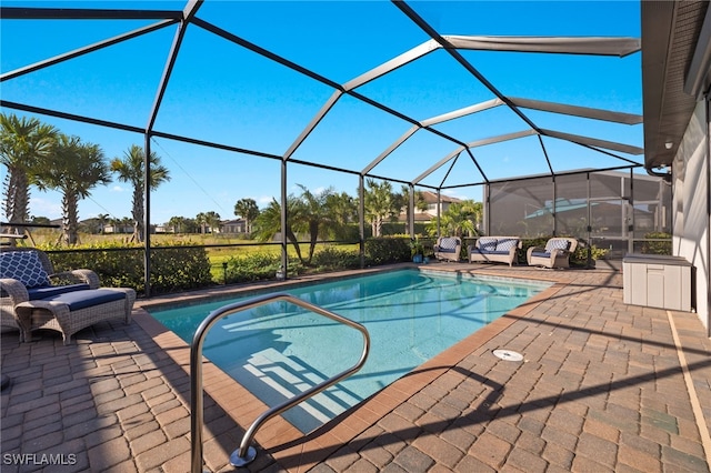 view of pool with glass enclosure and a patio area