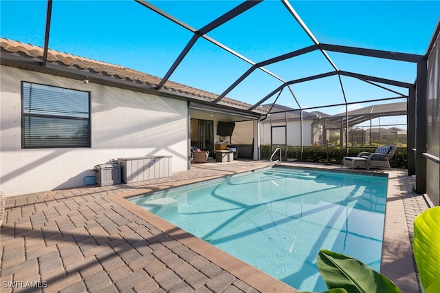 view of swimming pool with a patio and a lanai