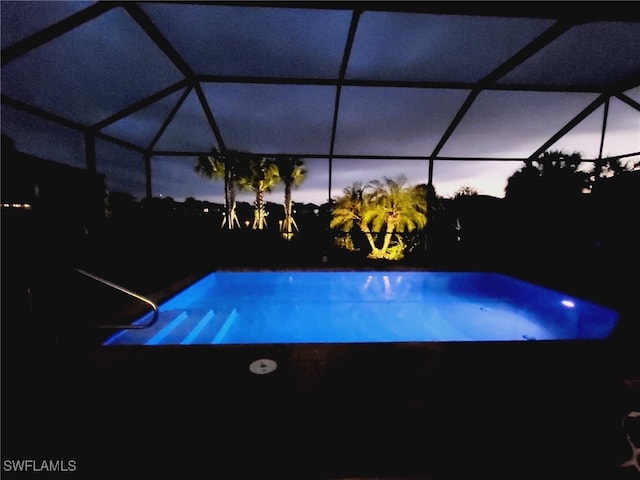 pool at dusk with a lanai