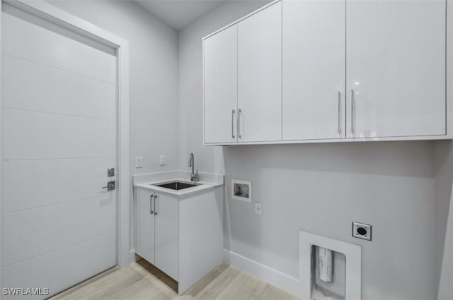 laundry area with cabinets, washer hookup, electric dryer hookup, sink, and light hardwood / wood-style floors