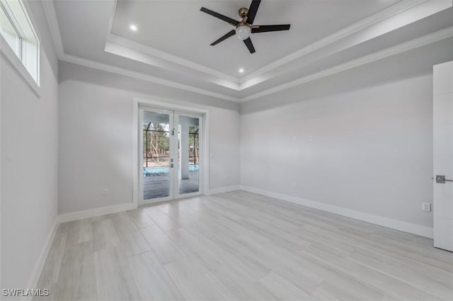 unfurnished room featuring french doors, ornamental molding, a raised ceiling, ceiling fan, and light hardwood / wood-style flooring