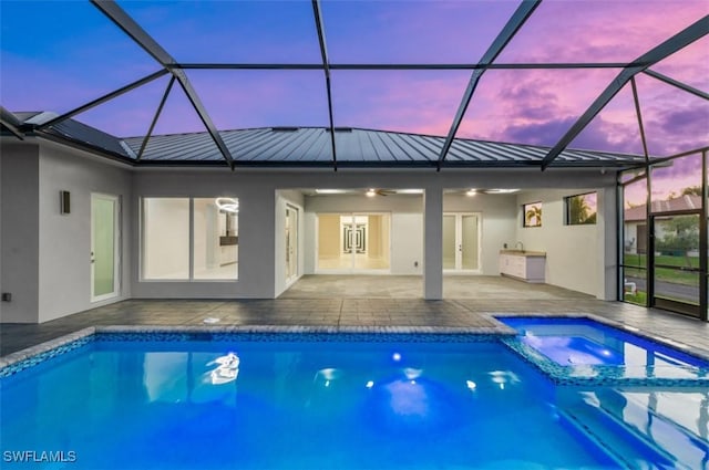 exterior space featuring an in ground hot tub, french doors, ceiling fan, glass enclosure, and a patio area