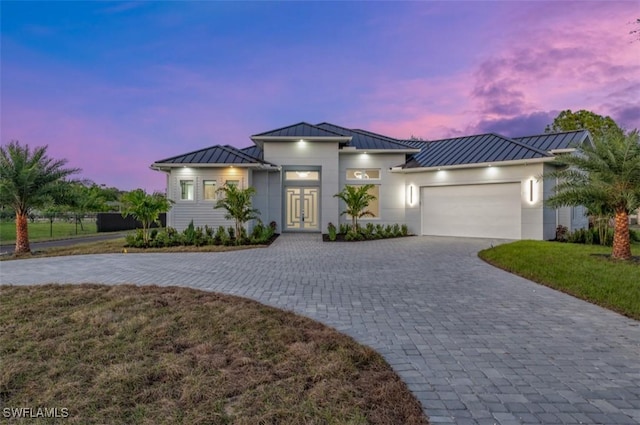 view of front of home with a garage and a lawn