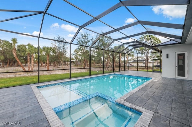 view of pool with an in ground hot tub, glass enclosure, and a patio area