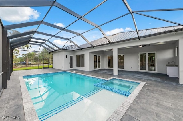 view of pool with ceiling fan, a patio area, a lanai, and french doors