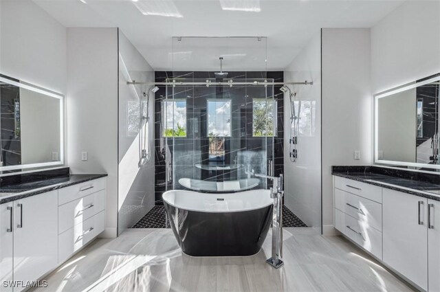 bathroom featuring vanity and independent shower and bath