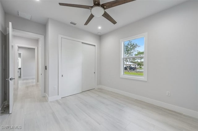 unfurnished bedroom featuring ceiling fan, a closet, and light hardwood / wood-style flooring