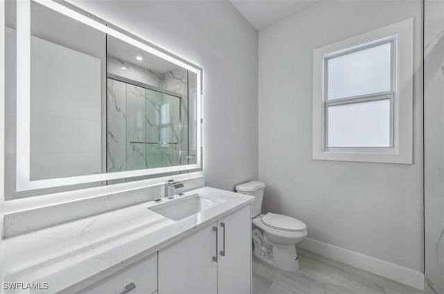 bathroom with hardwood / wood-style floors, vanity, toilet, and walk in shower