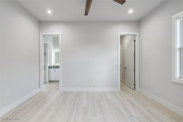 spare room with ceiling fan and light wood-type flooring