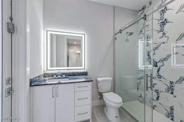 bathroom with vanity, hardwood / wood-style flooring, toilet, and walk in shower