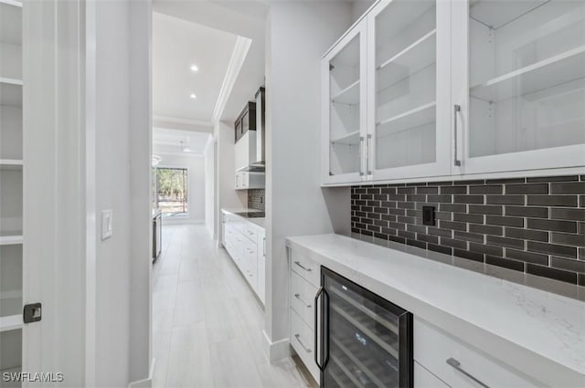 bar with white cabinets, backsplash, wine cooler, and crown molding