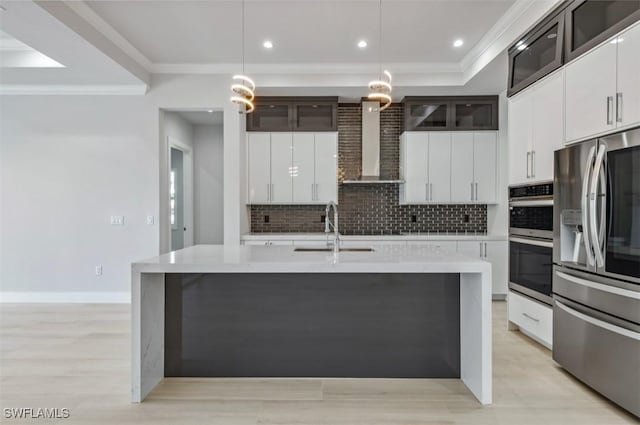 kitchen with white cabinetry, sink, wall chimney exhaust hood, hanging light fixtures, and appliances with stainless steel finishes